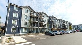 Kamloops apartment for rent - A row of modern apartment buildings with parking in front.