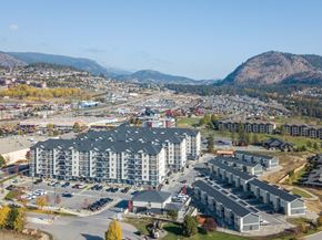 Kelowna apartment for rent - A large building complex with a parking lot in front of it.