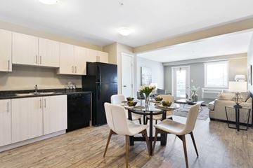 Kelowna apartment for rent - A modern kitchen with a dining table set for two.