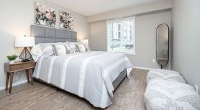 Winnipeg apartment for rent - A bedroom with queen sized bed, night stands and dog bed. A window with blinds on the outer wall