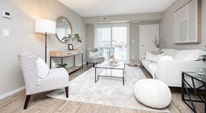 Winnipeg apartment for rent - A modern living room with a white sofa, chairs, coffee table and a large glass sliding balcony door