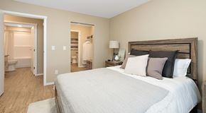 St. Albert apartment for rent - A bedroom with a queen sized bed and a walk in closet leading to a bathroom