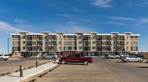 Lethbridge apartment for rent - A large apartment building with a large parking lot in front