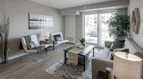 Penticton apartment for rent - A living room with a couch, chairs, and a coffee table with a large glass sliding door