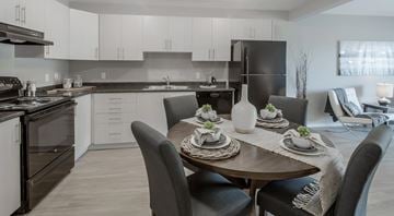 Penticton apartment for rent - A modern kitchen with a dining table set for two.