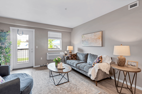 Courtenay apartment for rent - A living room with a grey couch, a coffee table, and a lamp.