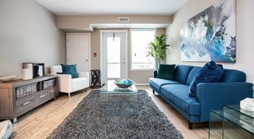 Penticton apartment for rent - A living room with a blue couch and a glass coffee table.