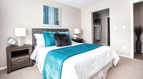 North Cowichan apartment for rent - A bedroom with queen sized bed, nightstands, and entrance to walk in closet
