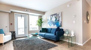 North Cowichan apartment for rent - A living room with a blue couch and a glass table.