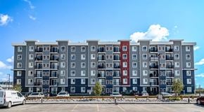 Winnipeg apartment for rent - A large apartment building with a parking lot in front.