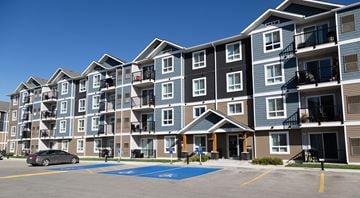 Winnipeg apartment for rent - A large apartment complex with a car parked in front.