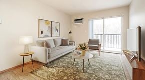 Winnipeg apartment for rent - A living room with a couch, chair and coffee table with a large glass sliding door