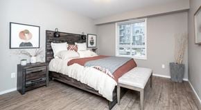 Winnipeg apartment for rent - A bedroom with a bed, nightstand, and a window.