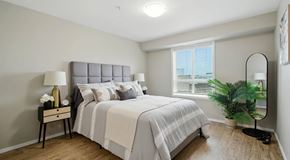 Saskatoon apartment for rent - A bedroom with a bed, nightstand, window