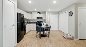 Saskatoon apartment for rent - A white kitchen, with light cabinets and black appliances a round kitchen table set for four