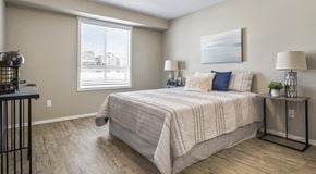 Lethbridge apartment for rent - A bedroom with a large bed and a painting on the wall.