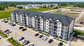 Winnipeg apartment for rent - A large apartment complex with a parking lot in front.