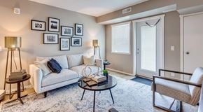 Calgary apartment for rent - A living room with a white couch, a coffee table, and a chair.