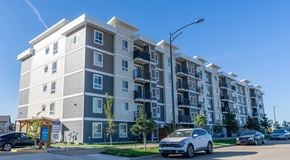 Edmonton apartment for rent - A modern apartment building with cars parked in front.
