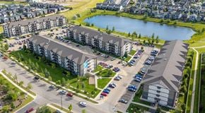 St. Albert apartment for rent - A large apartment complex with a parking lot between buildings and street parking out front