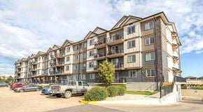 St. Albert apartment for rent - A large apartment building with a parking lot in front.