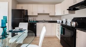 Portage La Prairie apartment for rent - A modern kitchen with black appliances and white cabinets.