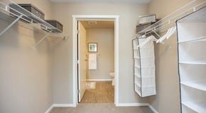 Winnipeg apartment for rent - A walk through closet with wire shelving leading to an ensuite