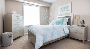 Portage La Prairie apartment for rent - a bedroom with dresser, night stands and large window with natural light
