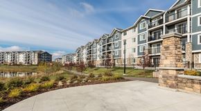 Edmonton apartment for rent - A row of modern apartment buildings with a paved walkway in front.
