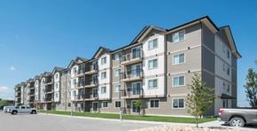 Selkirk apartment for rent - A row of modern apartment buildings with cars parked in front.