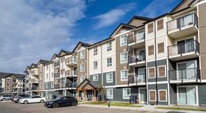 Edmonton apartment for rent - A row of modern apartment buildings with cars parked in front.