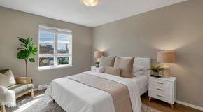 Campbell River apartment for rent - A bedroom with a large bed, a nightstand, and a chair.