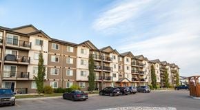 Edmonton apartment for rent - A large apartment building with cars parked in front.