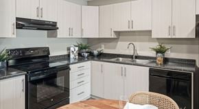 Medicine Hat apartment for rent - A modern kitchen with black appliances and white cabinets.