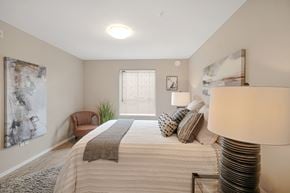 North Cowichan apartment for rent - A well-lit bedroom with a large bed and a chair.