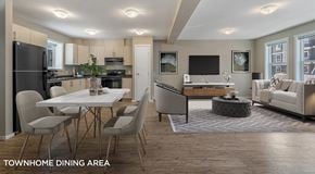 Port Alberni townhouse for rent - An open concept townhome with light kitchen cabinets, black appliances and rectangular table off to the side. A small pantry separates the two spaces with an open living room with two large windows on the other side