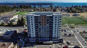 Campbell River apartment for rent - A large white building with a parking lot in front of it.