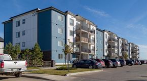 Saskatoon apartment for rent - A row of apartment buildings with cars parked in front.