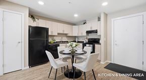 Lethbridge apartment for rent - A modern apartment kitchen with light cabinets, black appliances and round table with four chairs