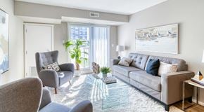 Winnipeg apartment for rent - A bright living room with sliding door, large couch and chairs