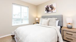 Parksville apartment for rent - A bedroom with a large bed, two lamps, and a painting on the wall.