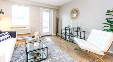 Kelowna apartment for rent - A living room with a white couch and a glass table.