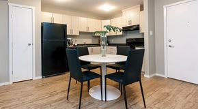 Parksville apartment for rent - An open kitchen with light cabinets and black appliances. A round table with four chairs in the center and pantry door