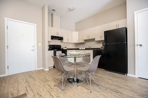 Winnipeg apartment for rent - A kitchen with a black refrigerator and a table with chairs.