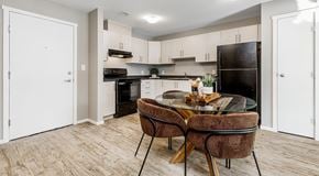 Edmonton apartment for rent - A modern kitchen with light cabinets, black appliances and round table.