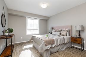 Edmonton apartment for rent - A bedroom with a large bed and a wooden table.
