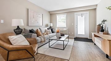 Kamloops apartment for rent - A living room with a brown leather chair and a glass coffee table.