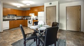Saskatoon apartment for rent - Large open kitchen with brown wooden cabinets and white appliances