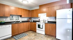 Edmonton apartment for rent - A kitchen with wooden cabinets and white appliances.