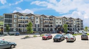 Kelowna apartment for rent - A large apartment building with a large parking lot out front